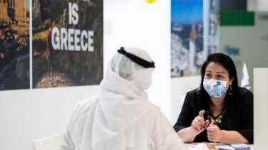 A man in an Arab suit talking with the woman at the event