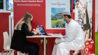 A woman presenting with a laptop to the man beside her