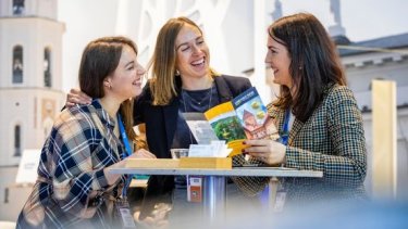 three women happy chatting while sitting in one table